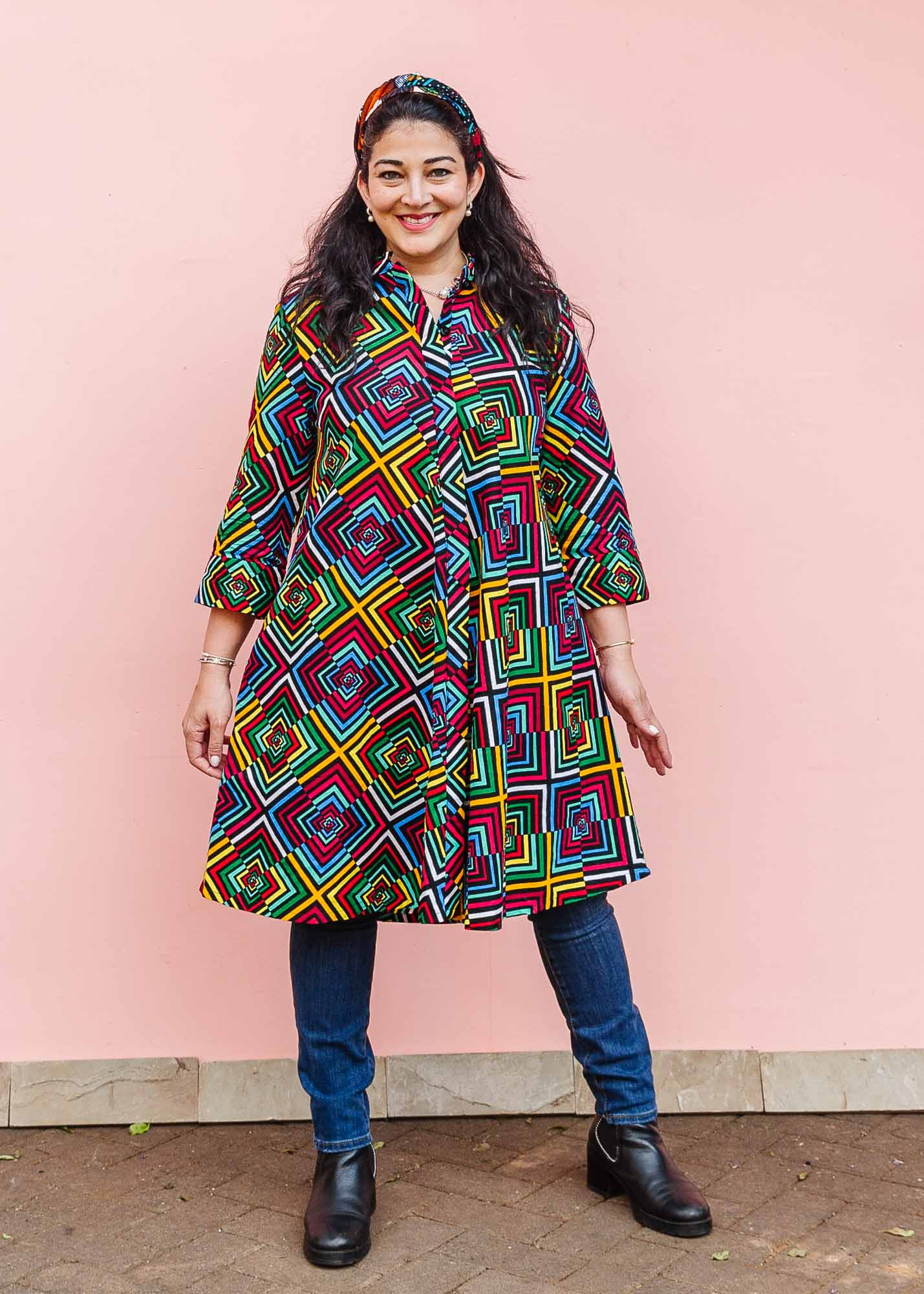The model is wearing geometric print with rainbow colored dress