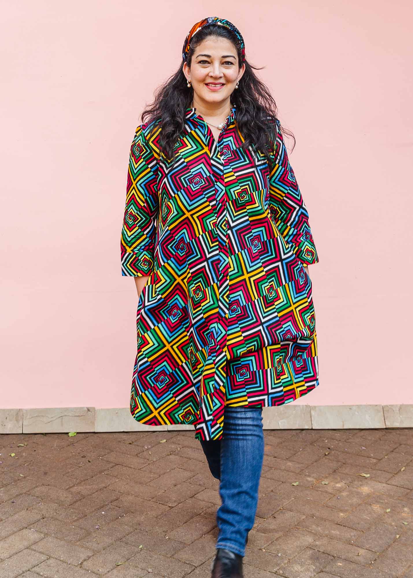 The model is wearing geometric print with rainbow colored dress