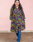 The model is wearing geometric print with rainbow colored dress