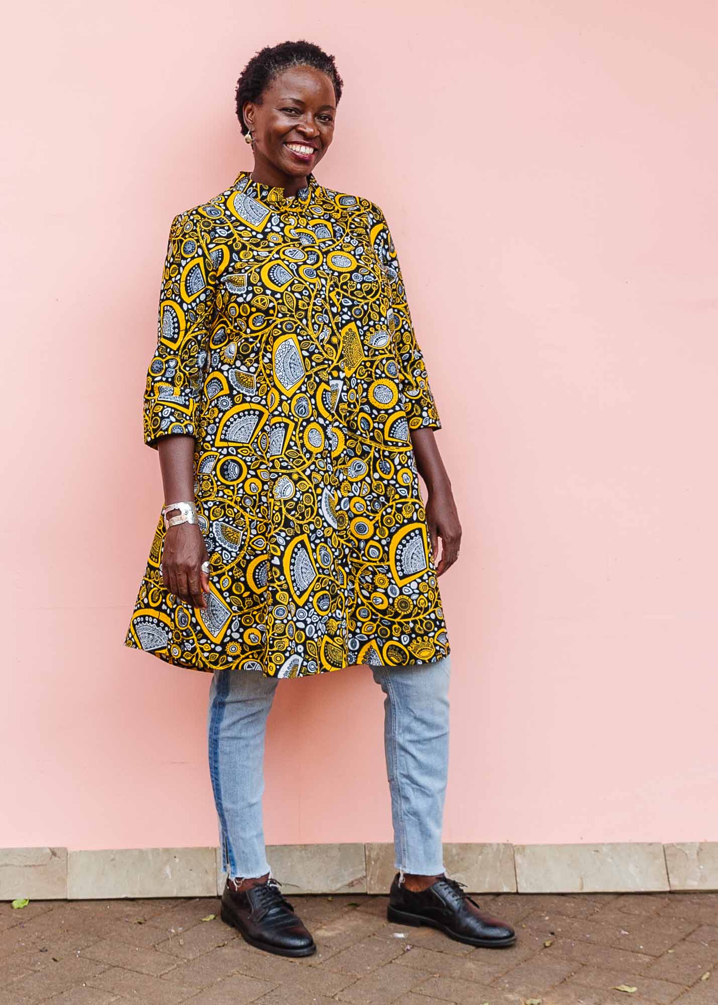 The model is wearing black dress with white and yellow botanical print