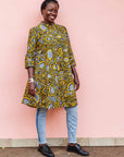 The model is wearing black dress with white and yellow botanical print