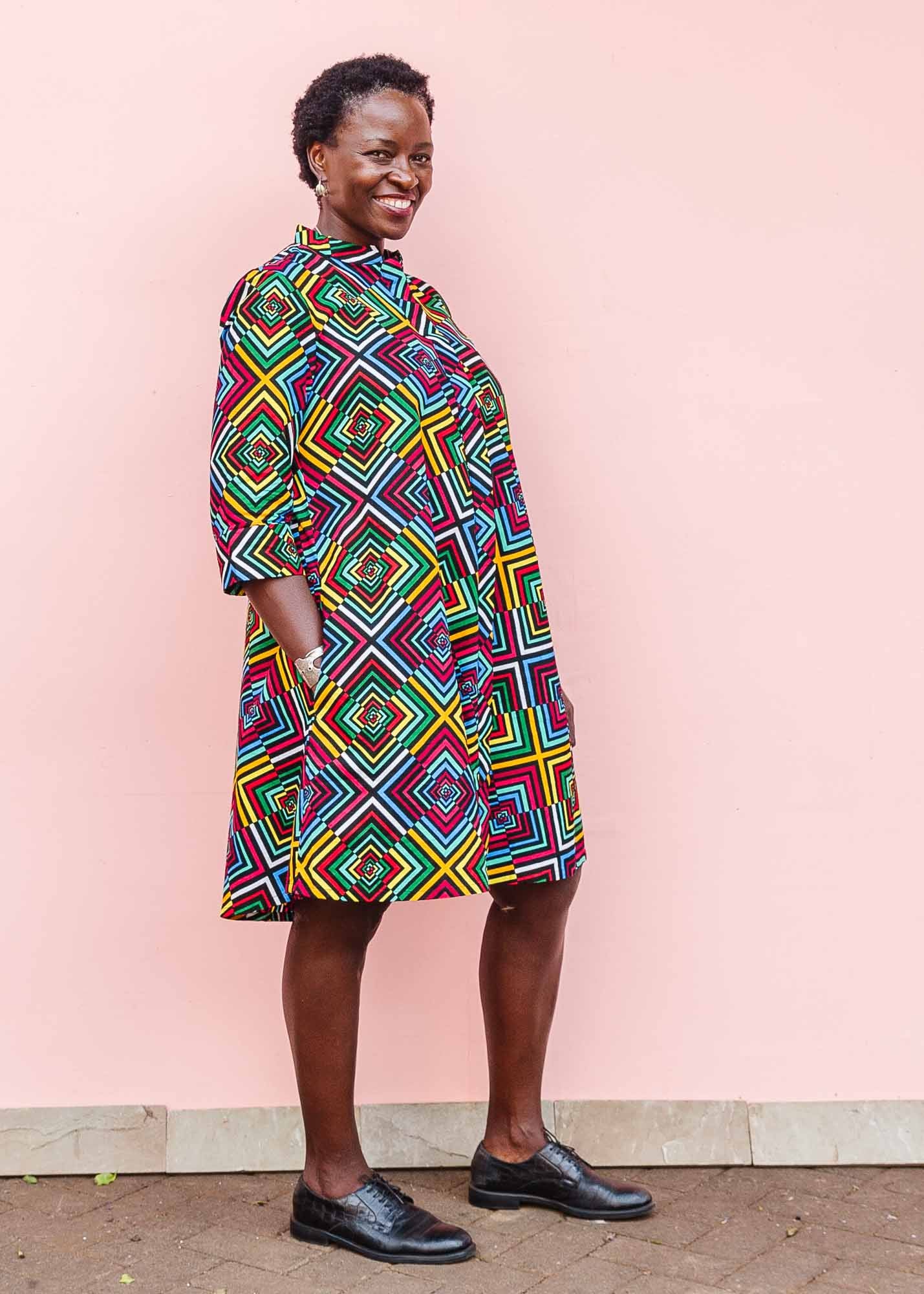 The model is wearing geometric print with rainbow colored dress
