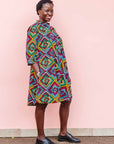 The model is wearing geometric print with rainbow colored dress 