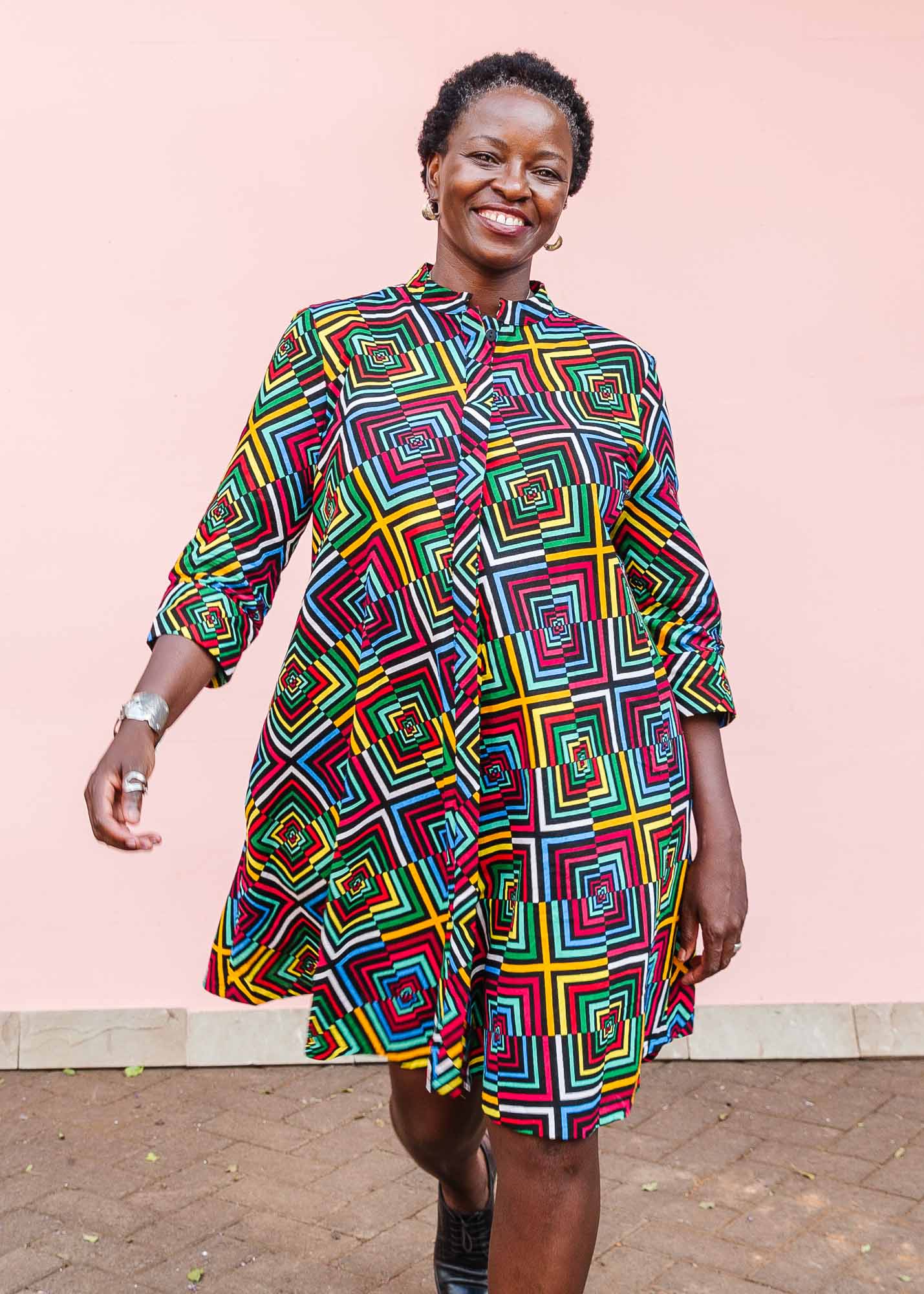 The model is wearing geometric print with rainbow colored dress