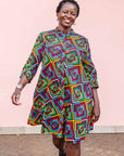 The model is wearing geometric print with rainbow colored dress 