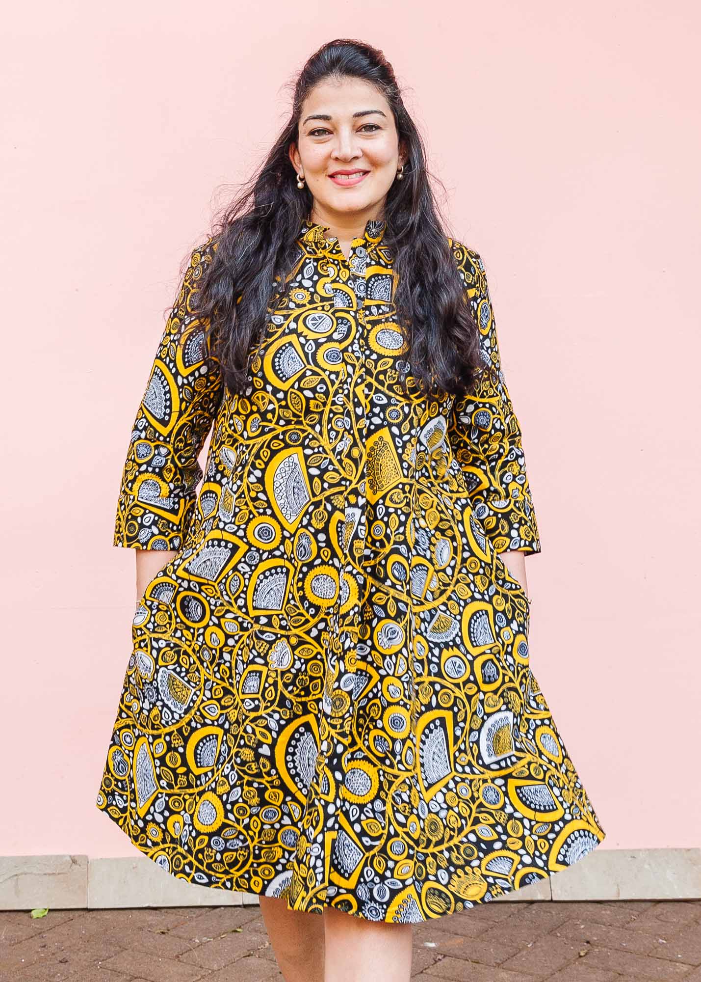 The model is wearing black dress with white and yellow botanical print