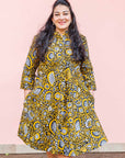 The model is wearing black dress with white and yellow botanical print