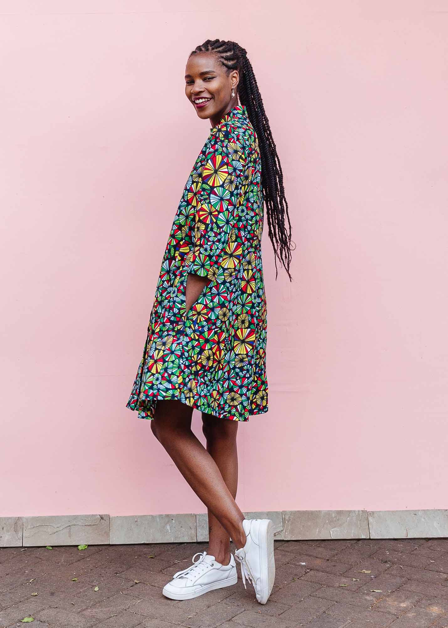 The model is wearing navy blue dress with rainbow color umbrella shaped print