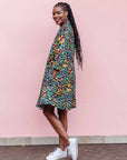 The model is wearing navy blue dress with rainbow color umbrella shaped print