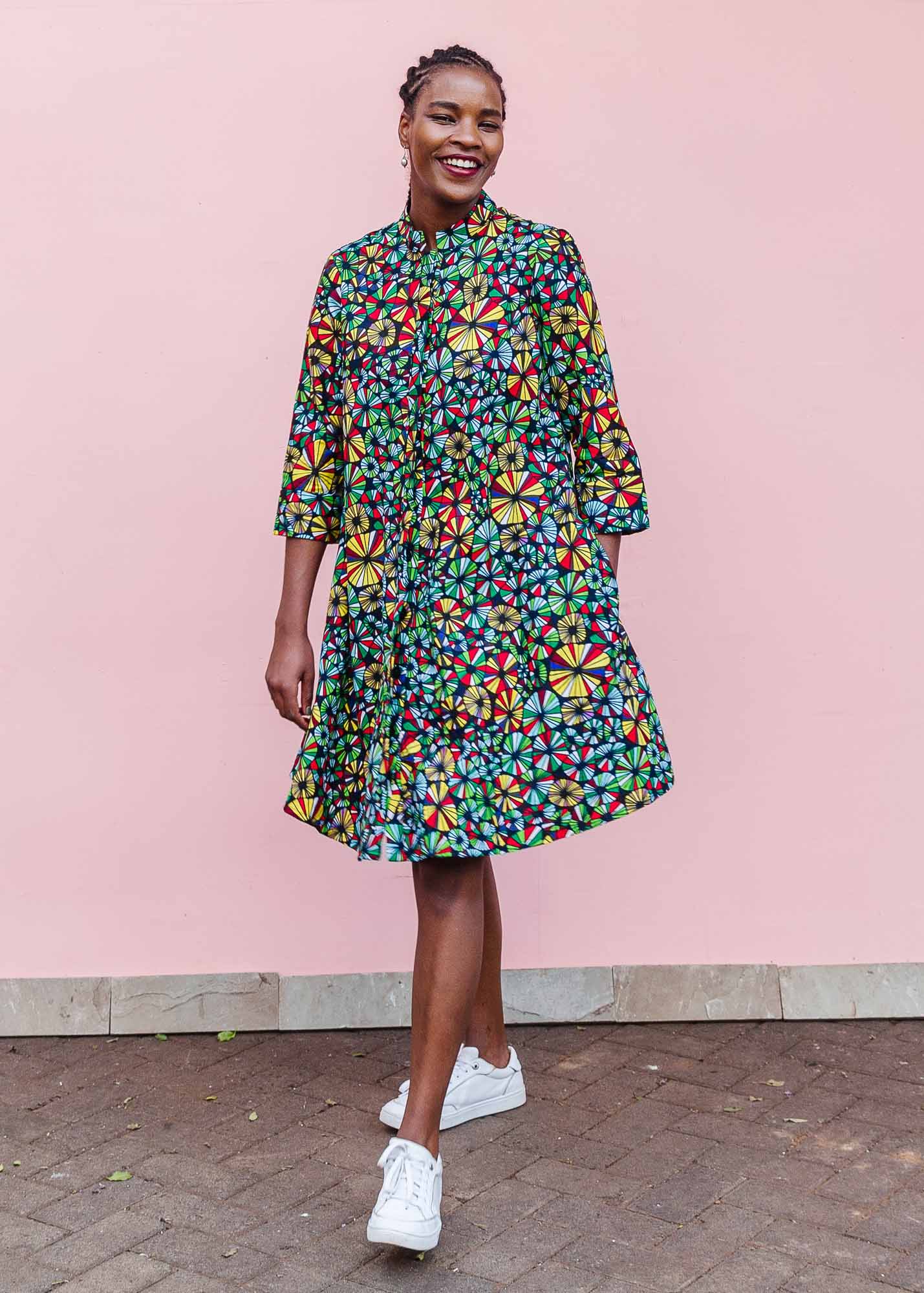 The model is wearing navy blue dress with rainbow color umbrella shaped print