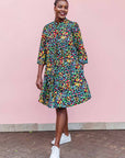 The model is wearing navy blue dress with rainbow color umbrella shaped print