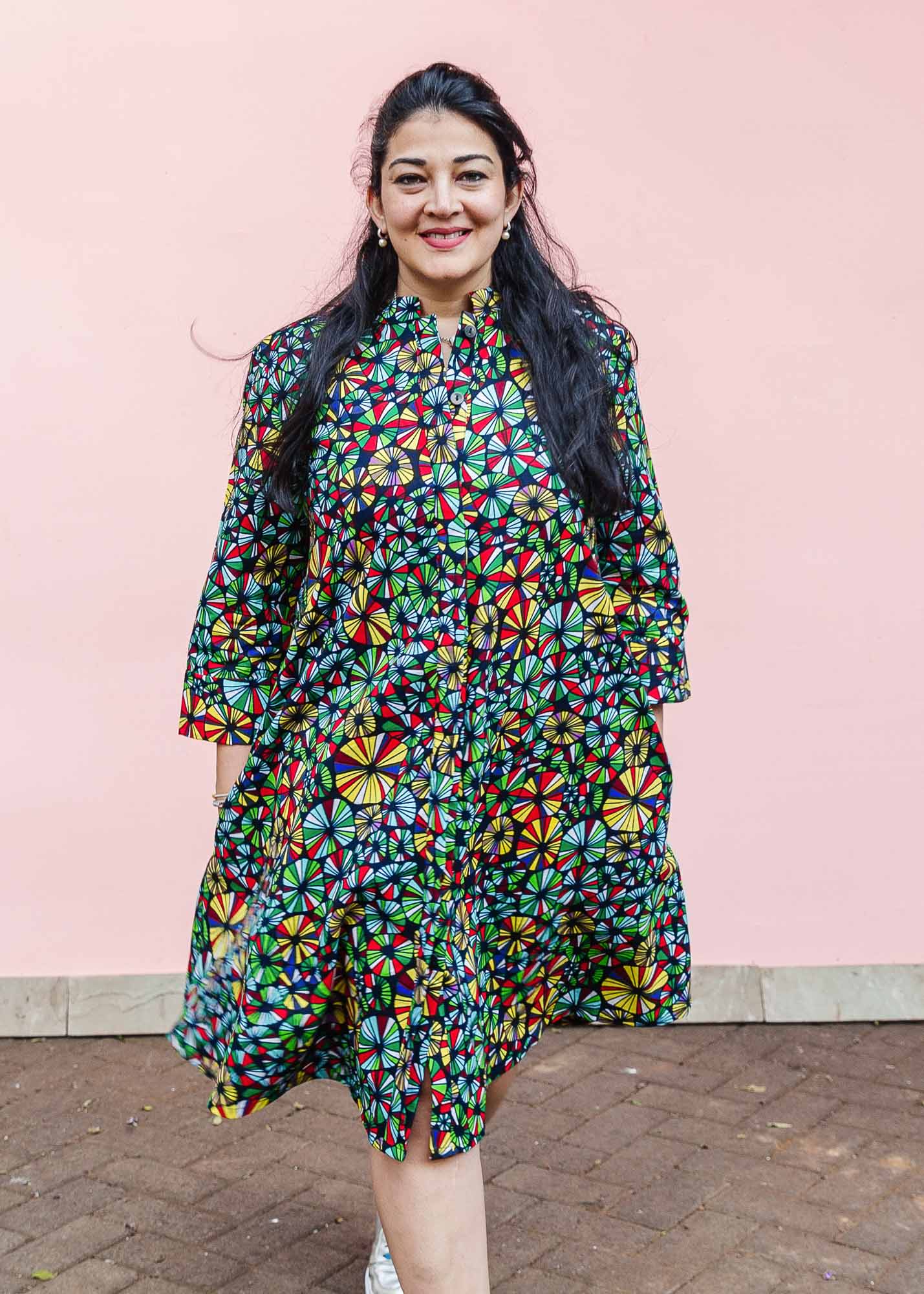 The model is wearing navy blue dress with rainbow color umbrella shaped print