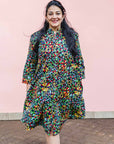 The model is wearing navy blue dress with rainbow color umbrella shaped print