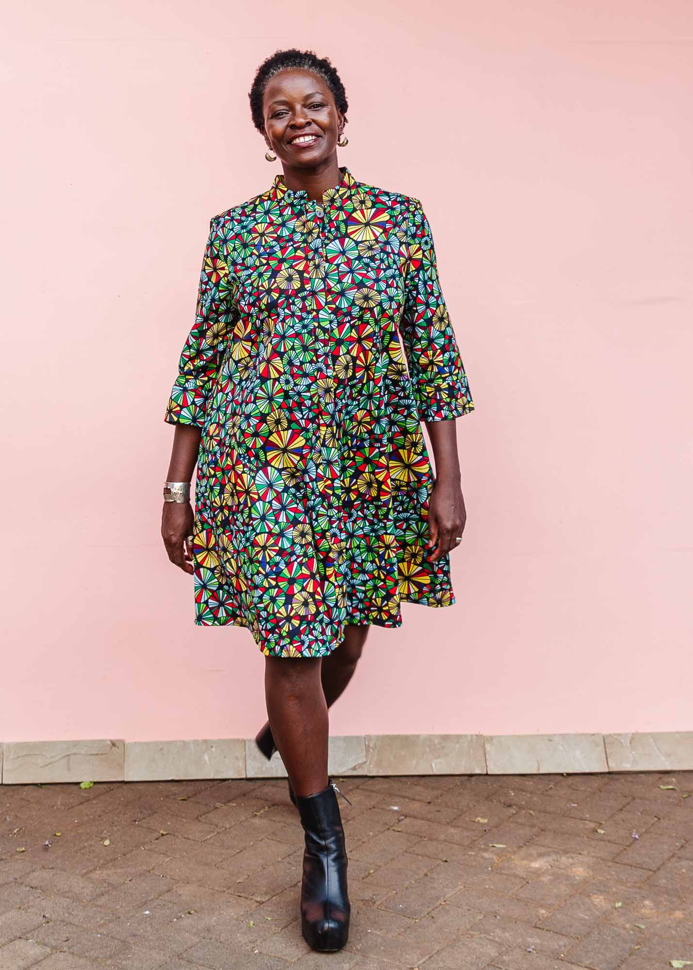 The model is wearing navy blue dress with rainbow color umbrella shaped print