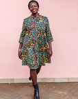 The model is wearing navy blue dress with rainbow color umbrella shaped print