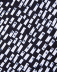 Close up display of black dress with white rectangles