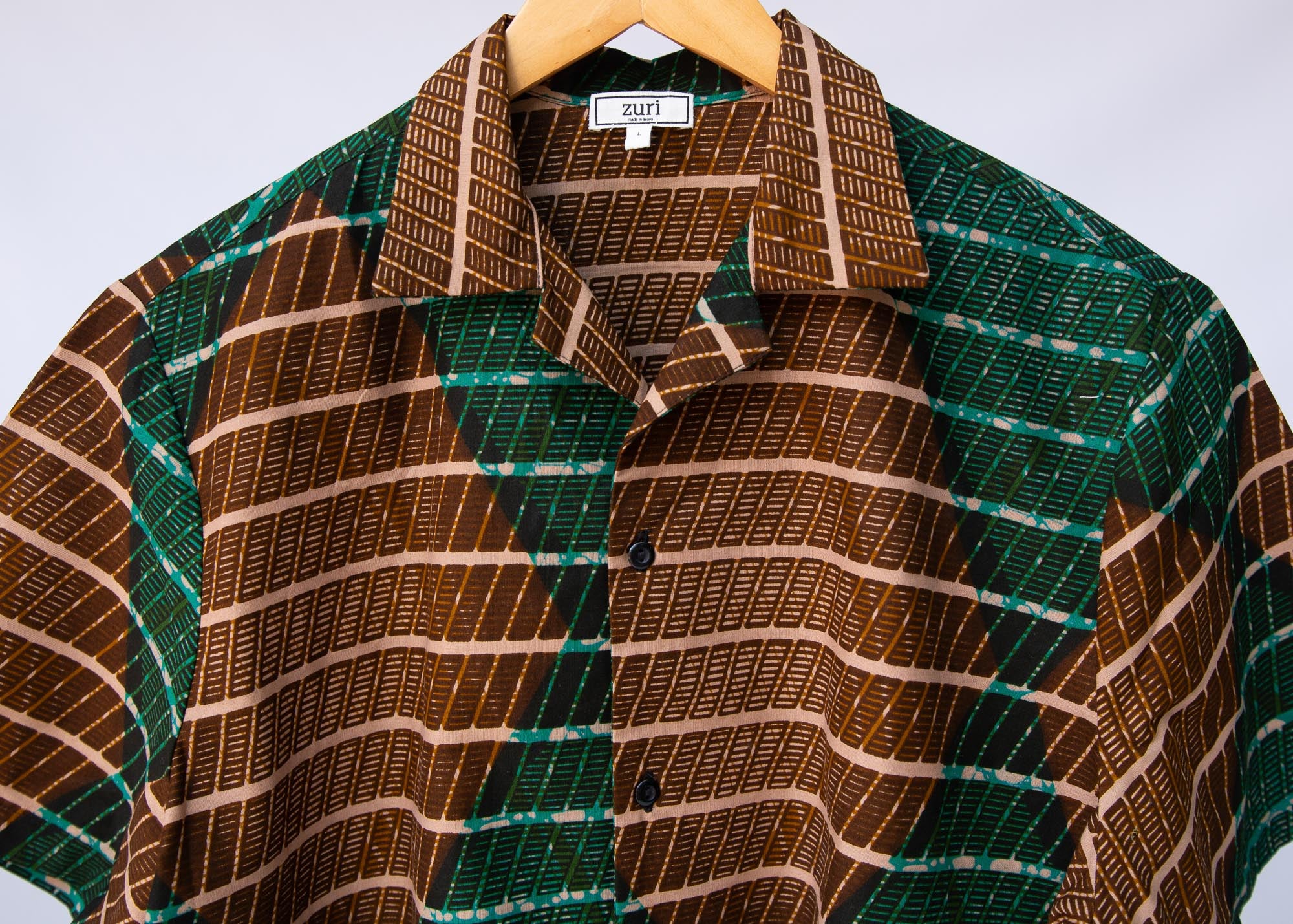 Display of  brown, camel, green and black diamond shaped geometric print shirt