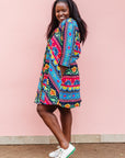 The model is wearing colorful mandala print dress