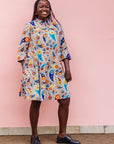 The model is wearing multi-colored paisley print dress