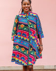 The model is wearing colorful mandala print dress