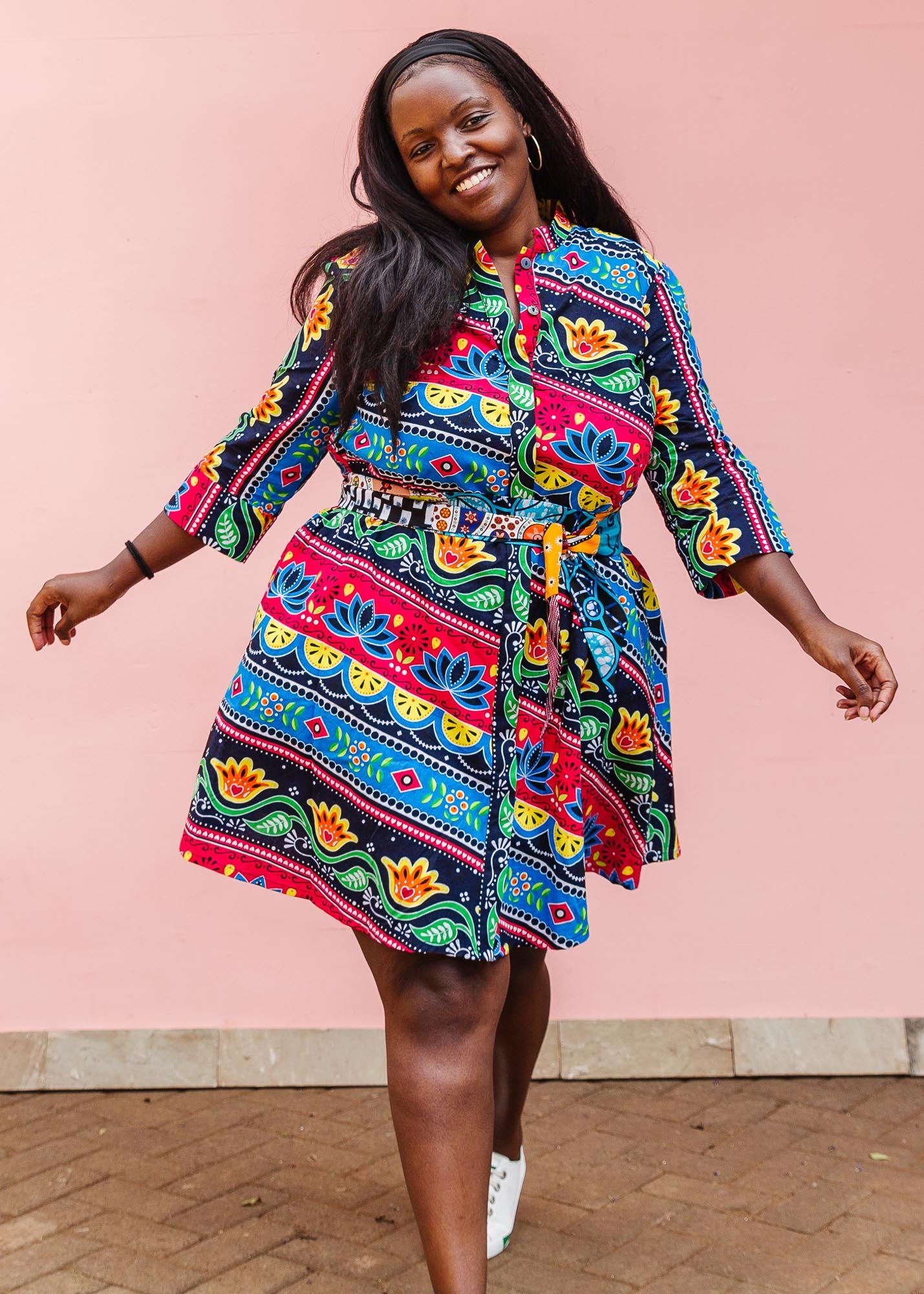 The model is wearing colorful mandala print dress