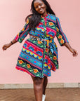 The model is wearing colorful mandala print dress