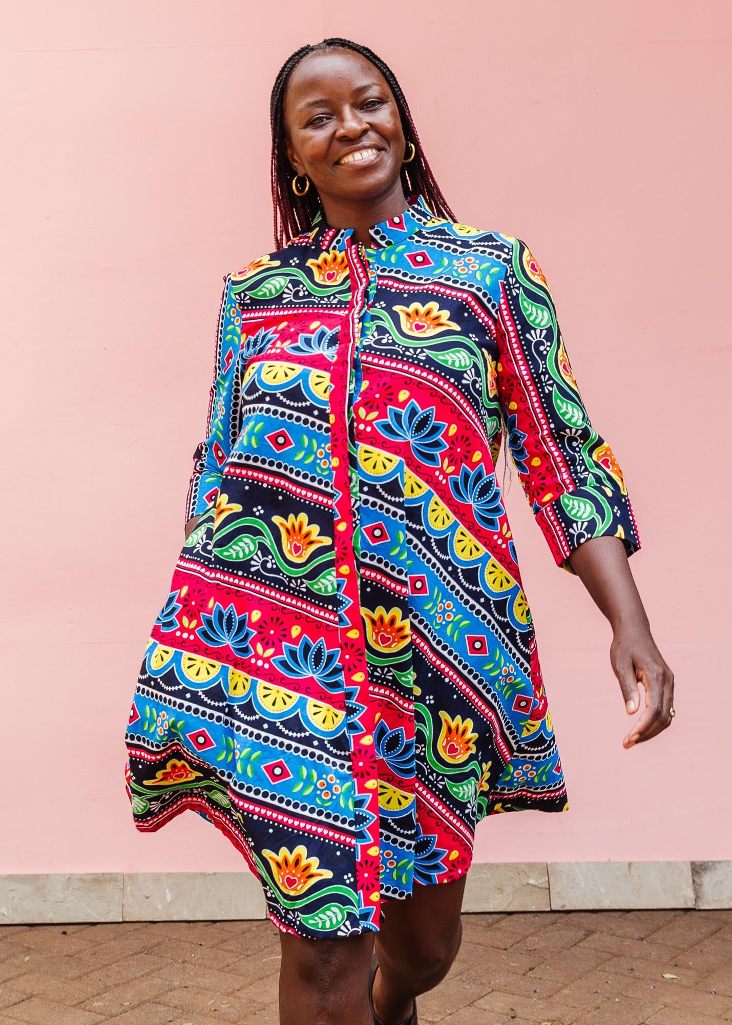 The model is wearing colorful mandala print dress