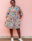 The model is wearing multi-colored paisley print dress
