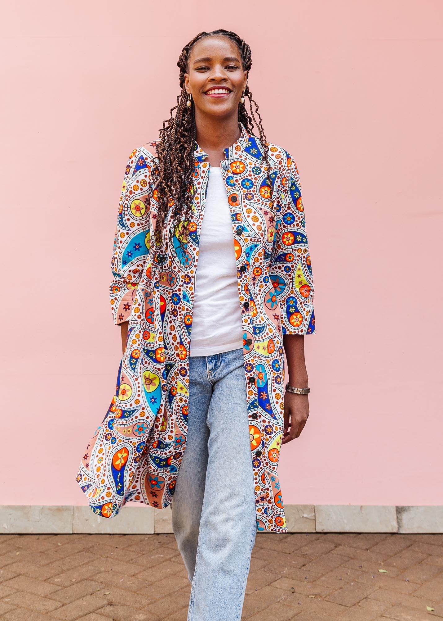 The model is wearing multi-colored paisley print dress