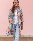 The model is wearing multi-colored paisley print dress
