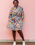 The model is wearing multi-colored paisley print dress