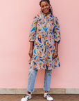 The model is wearing multi-colored paisley print dress