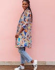 The model is wearing multi-colored paisley print dress