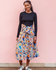 The model is wearing multi-colored paisley print dress