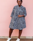 The model is wearing black dress with white rectangles