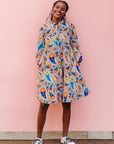 The model is wearing multi-colored paisley print dress