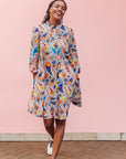 The model is wearing multi-colored paisley print dress