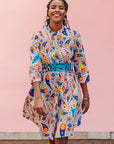 The model is wearing multi-colored paisley print dress
