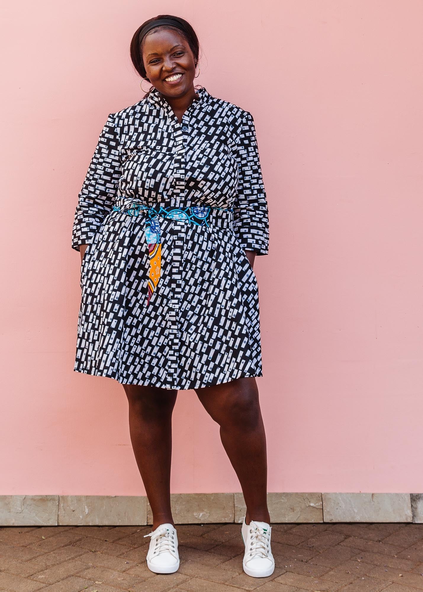 The model is wearing black dress with white rectangles