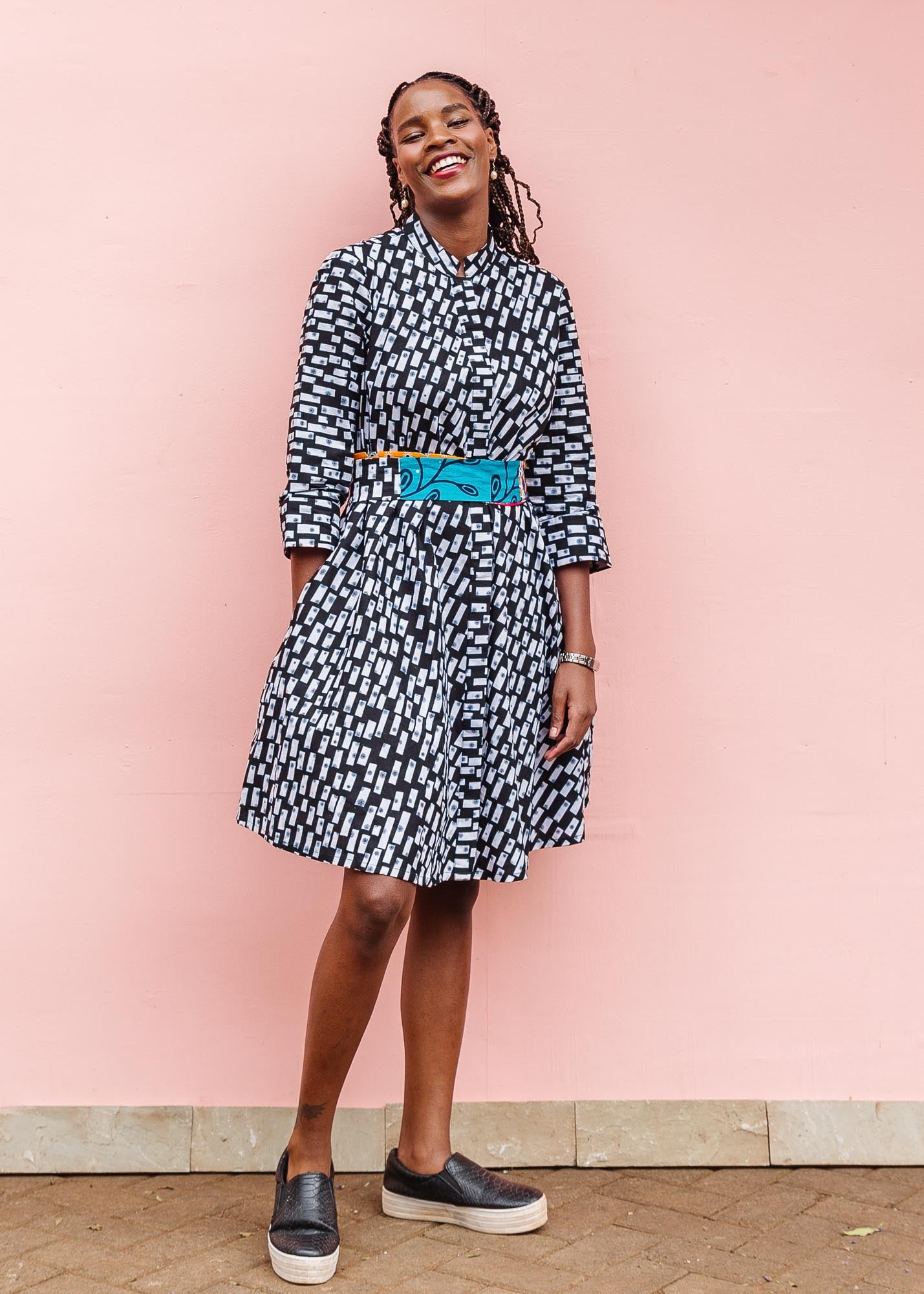 The model is wearing black dress with white rectangles