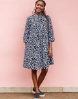 The model is wearing black dress with white rectangles