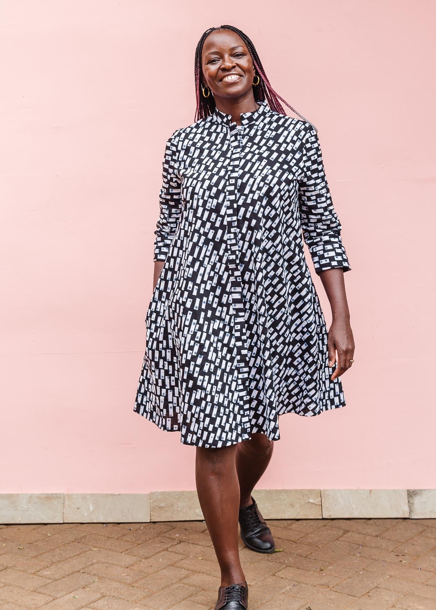 The model is wearing black dress with white rectangles