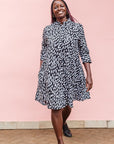 The model is wearing black dress with white rectangles