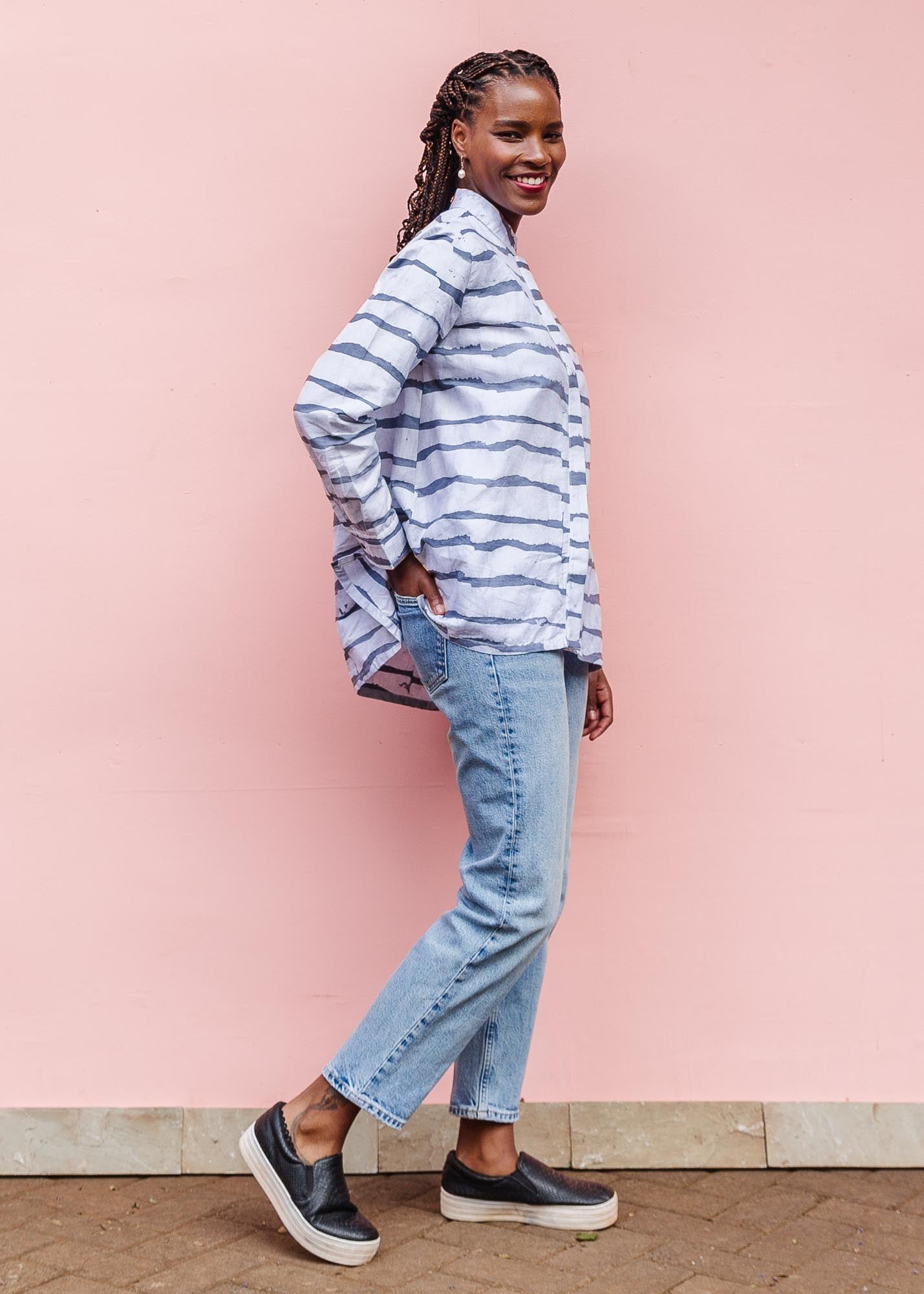 The model is wearing gray and white striped batik shirt