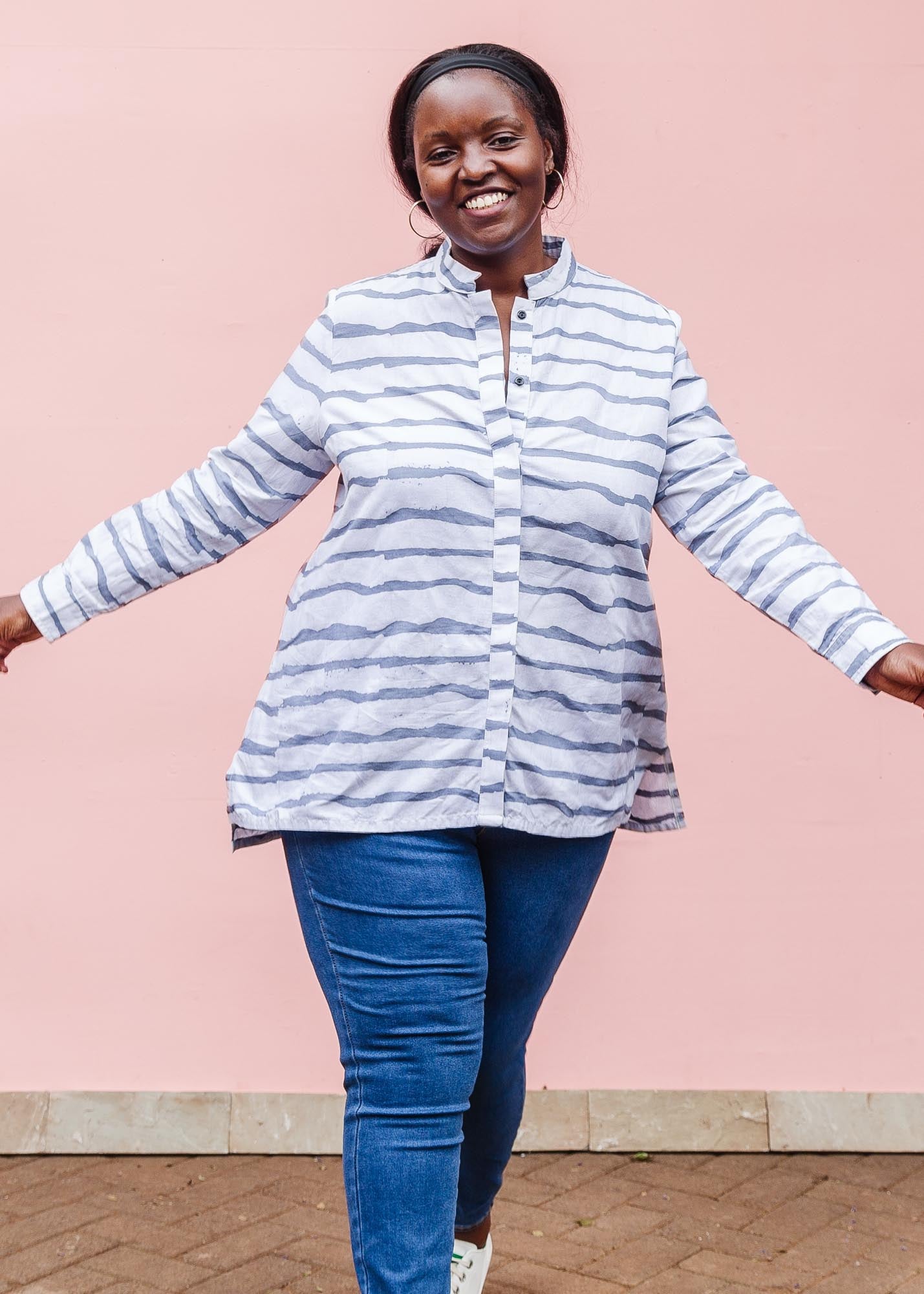 The model is wearing gray and white striped batik shirt