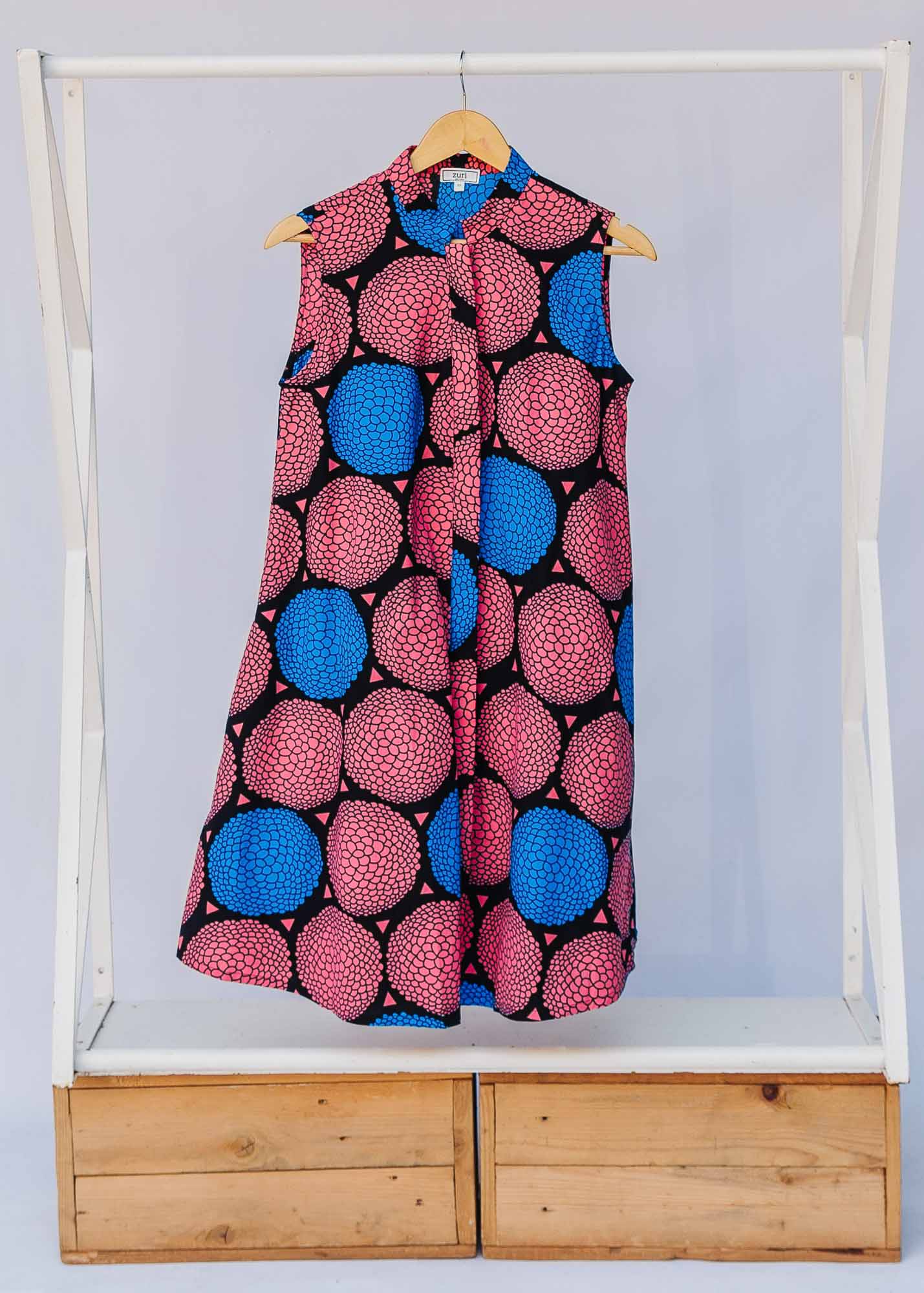 Display of coral, blue and black circular print dress