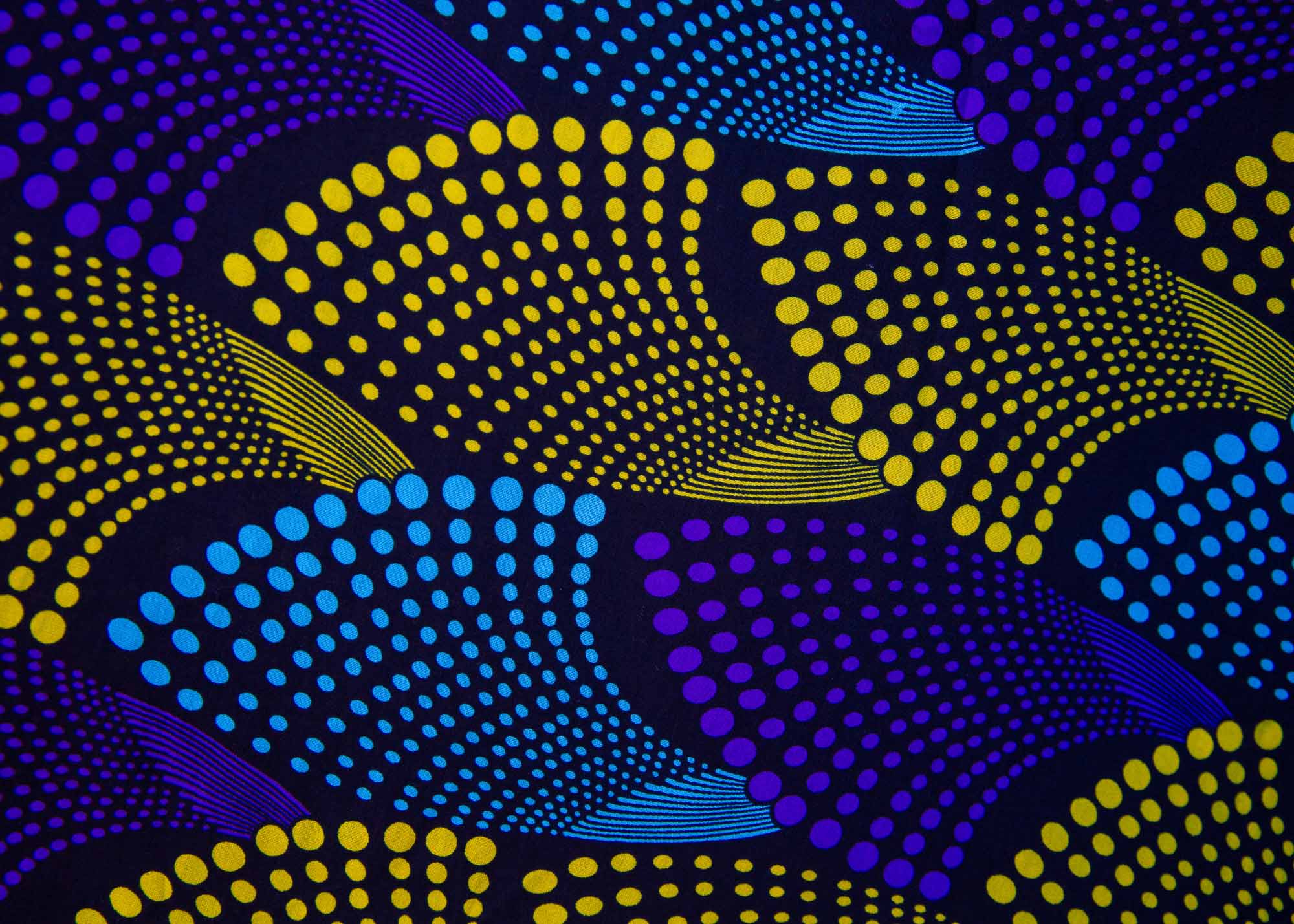 Close up display of black dress with purple , yellow and turquoise dotted fans
