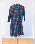 Display of pink, blue, turquoise and beige abstract line dress.
