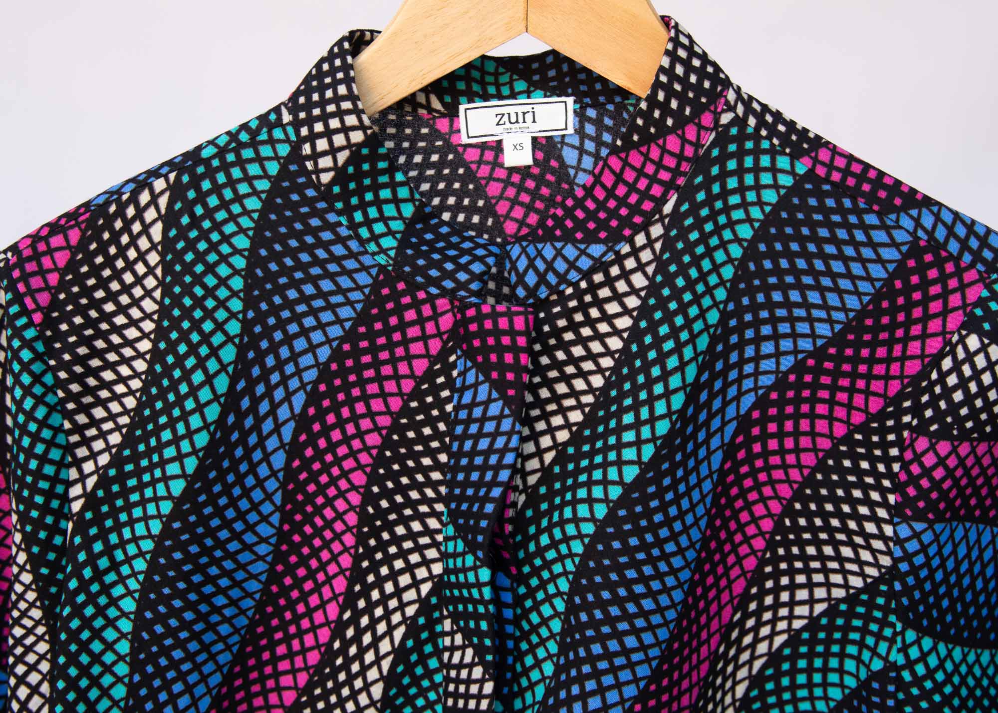 Display of pink, blue, turquoise and beige abstract line dress.