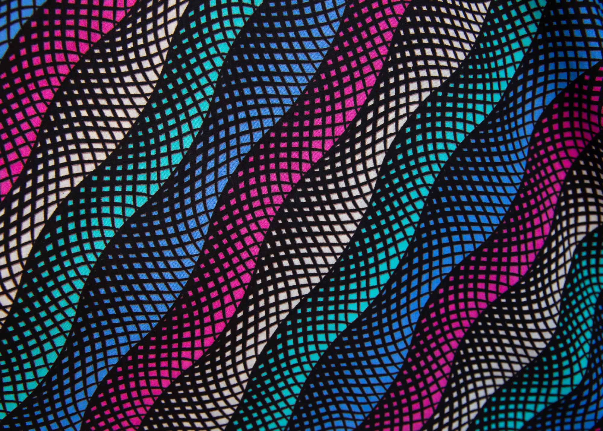Close up display of pink, blue, turquoise and beige abstract line dress.